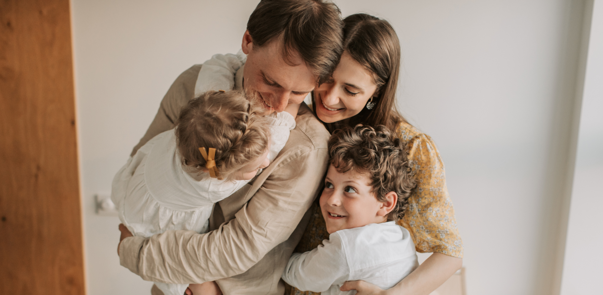 Junge Familie mit zwei Kindern in einer Gruppenumarmung