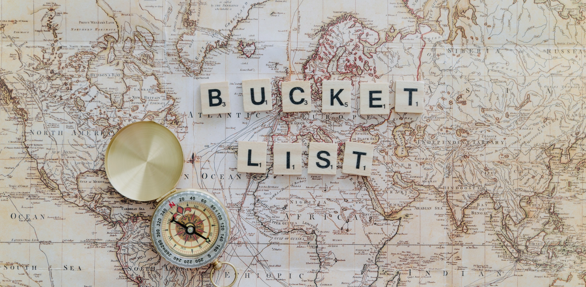 Weltkarte mit Aufschrift Bucket List und ein Kompass.