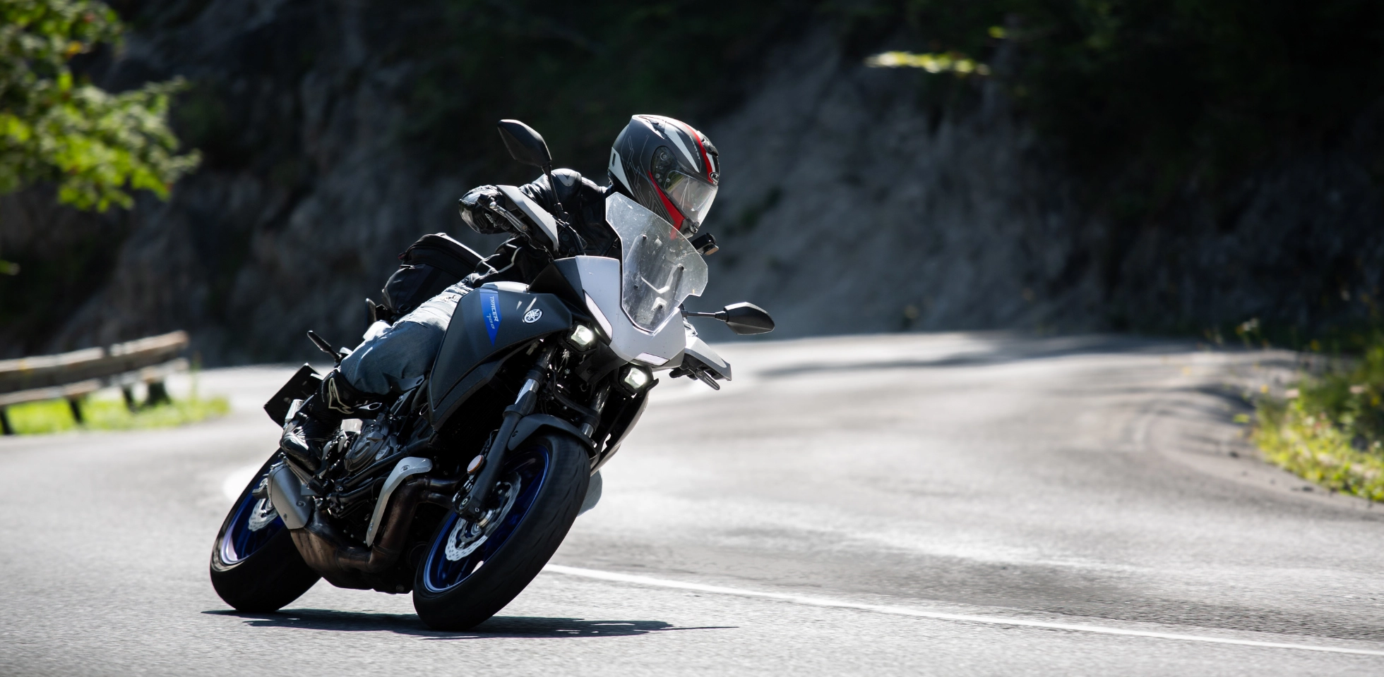 Motorradfahrer fährt in Schräglage durch eine Kurve.