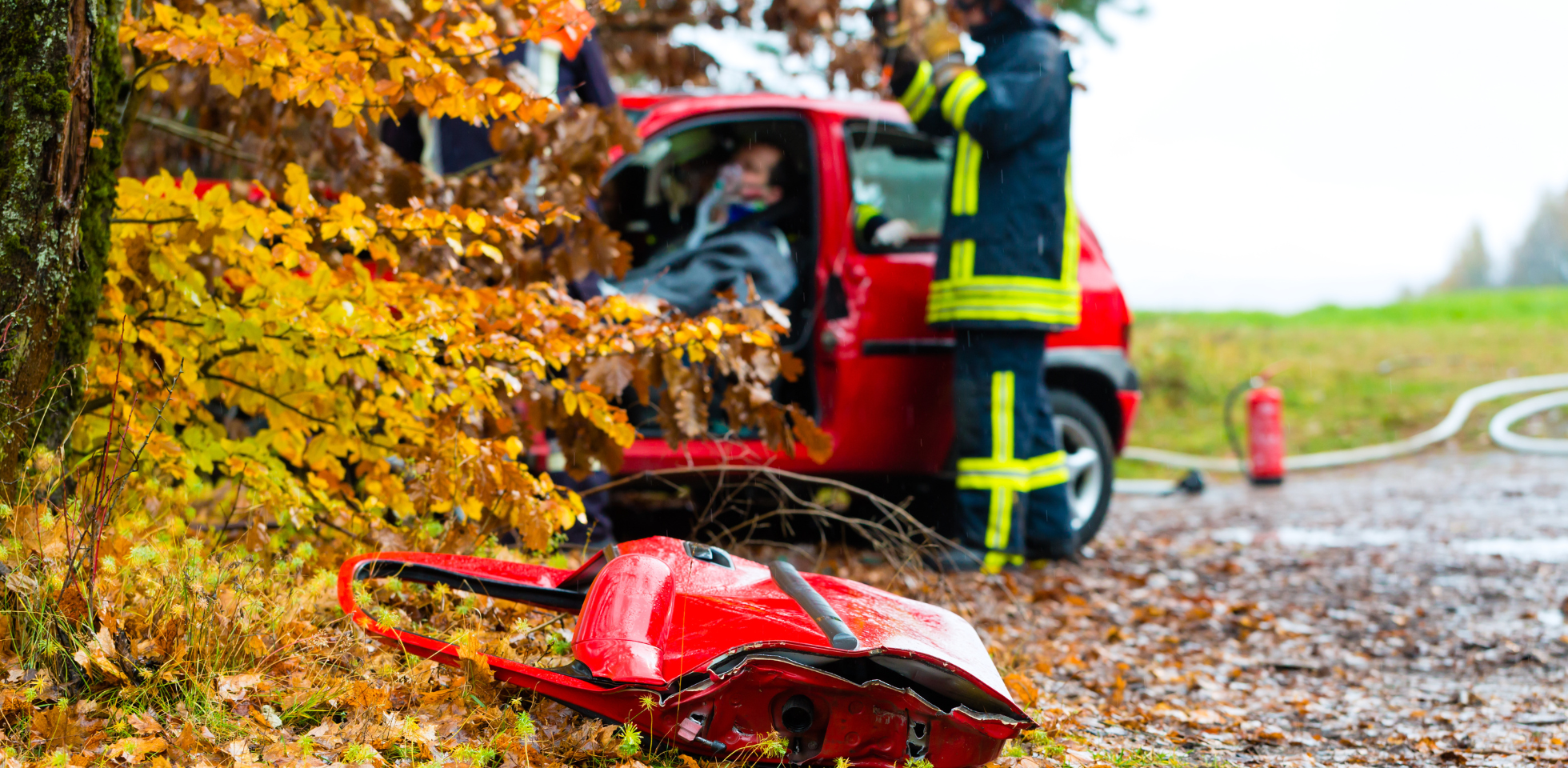Das Bild zeigt einen Sanitäter, der einem Autofahrer hilft.